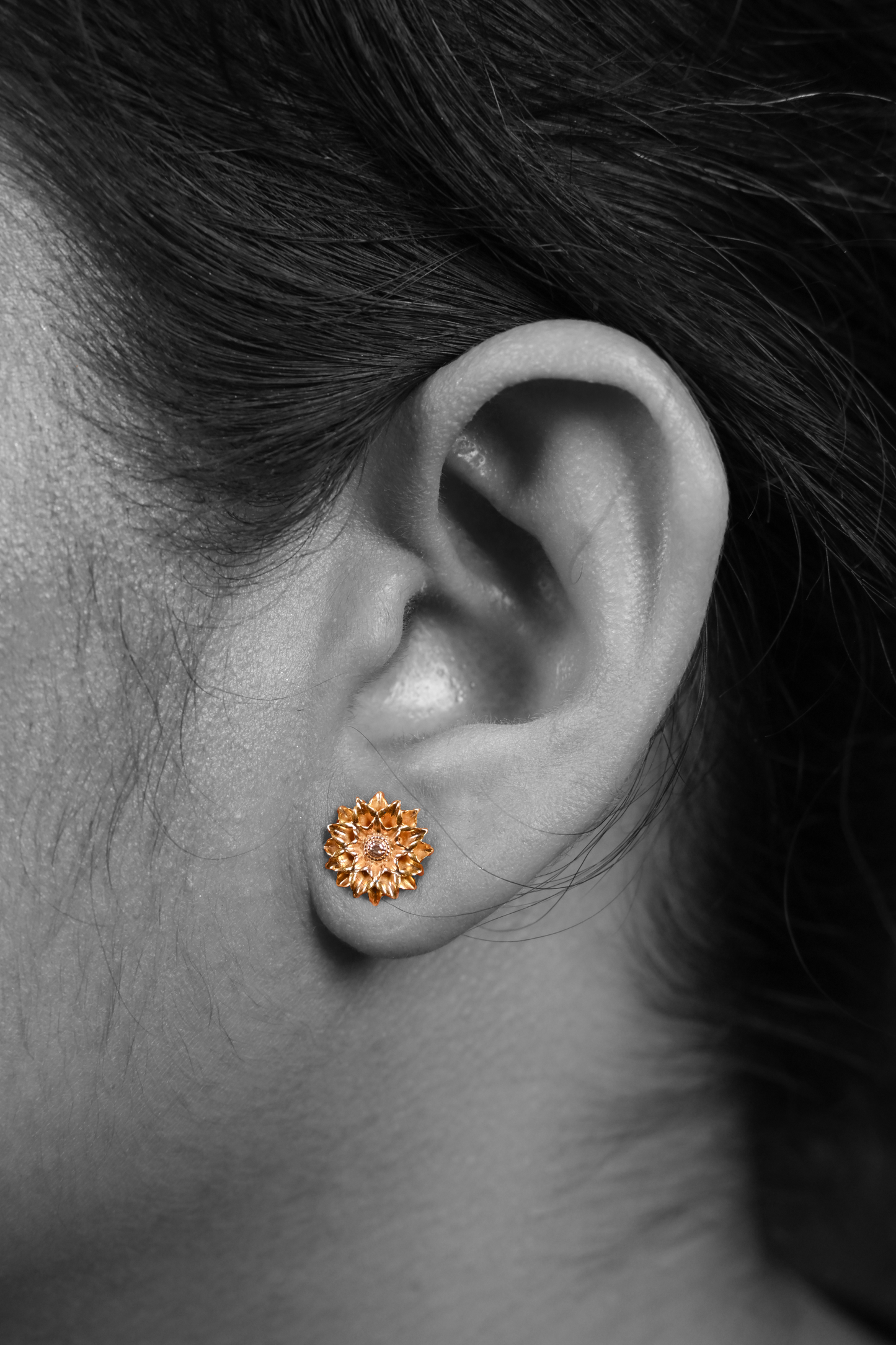 Model wearing Sculptyx Solaris Crest handcrafted 18K gold stud earrings.
