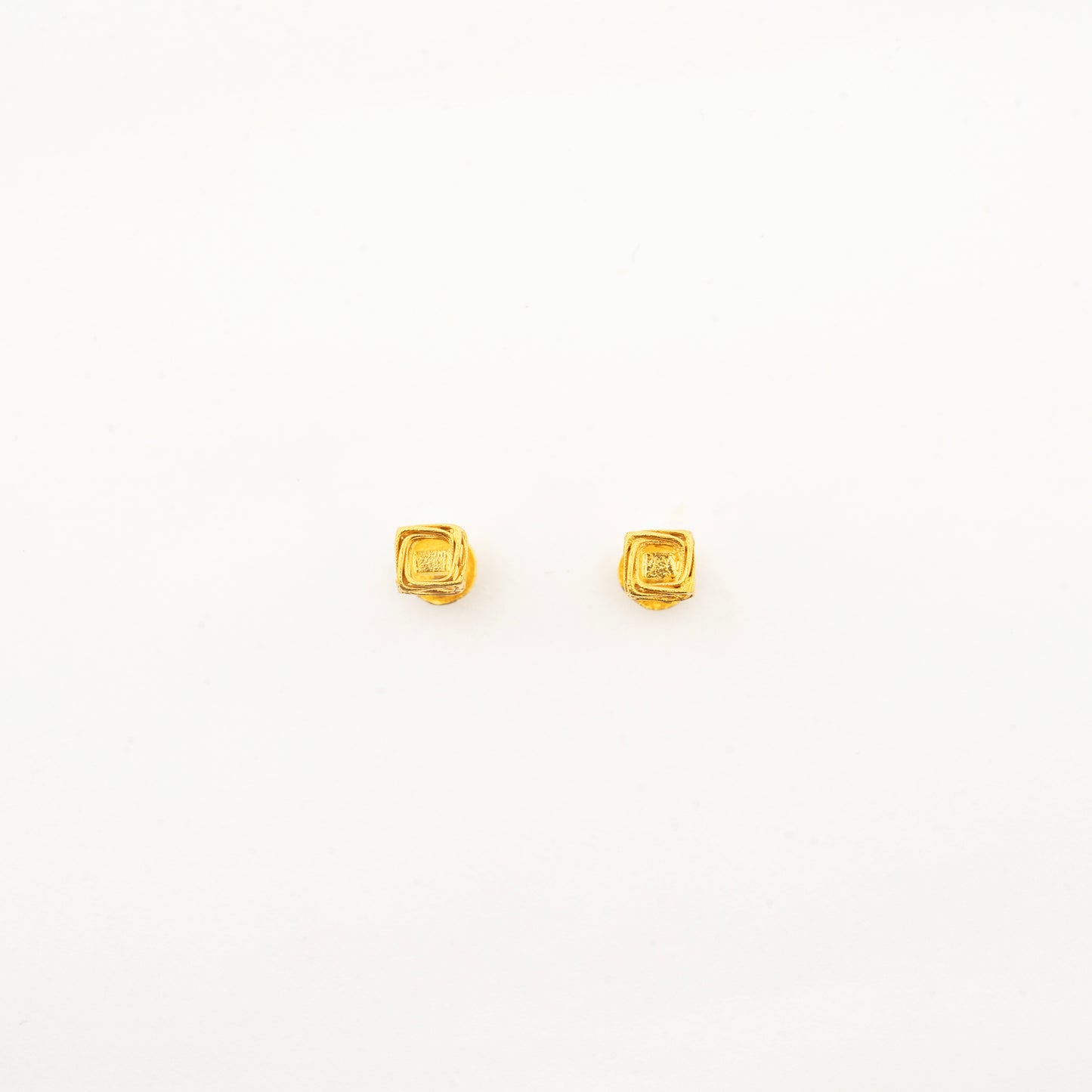 Pair of handcrafted Vertex Vault 18K Pair of handcrafted Vertex Vault 18K gold stud earrings displaying a modern geometric minimalist aesthetic.