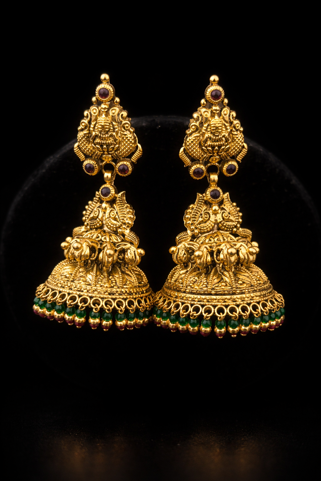 22K Gold Lakshmi Peacock Temple Jhumka earrings with green bead drops, ruby stone accents and antique finish.