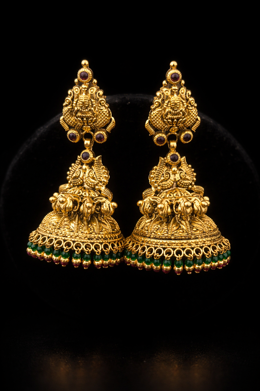 22K Gold Lakshmi Peacock Temple Jhumka earrings with green bead drops, ruby stone accents and antique finish.