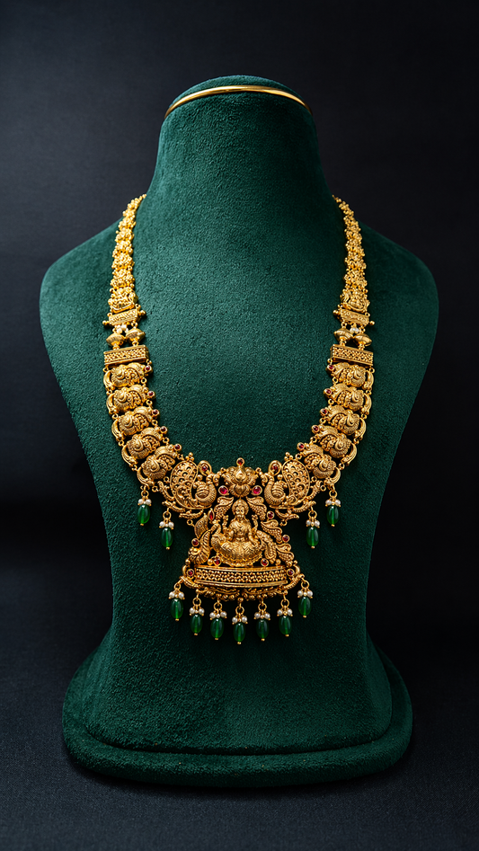 Handcrafted 22K Gold Royal Lakshmi Temple Haram necklace with Nakshi detailing, emerald green bead drops, and traditional South Indian bridal craftsmanship.