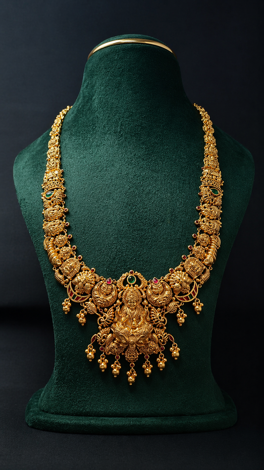 Handcrafted 22K Gold Shankha Chakra Lakshmi Temple Haram necklace with Nakshi detailing, green stone accents, and traditional South Indian bridal craftsmanship.