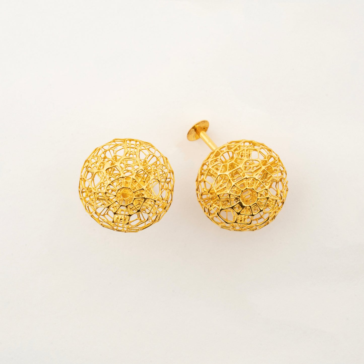 Close-up view of Celestara Orbs 18K gold stud earrings with intricate celestial-inspired texture.