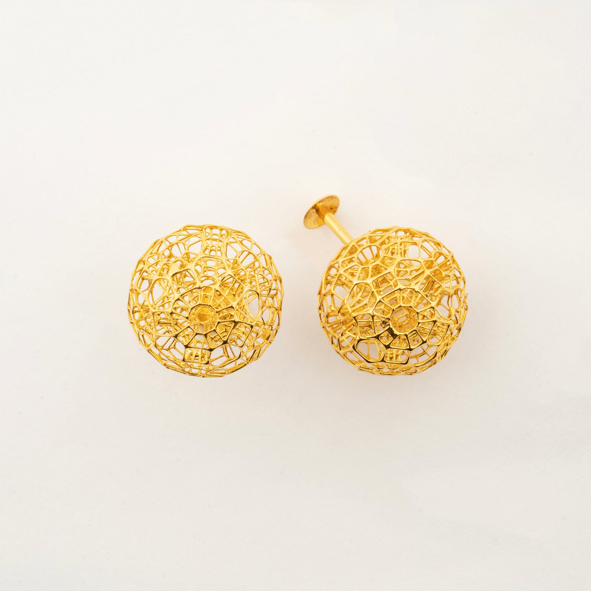 Close-up view of Celestara Orbs 18K gold stud earrings with intricate celestial-inspired texture.