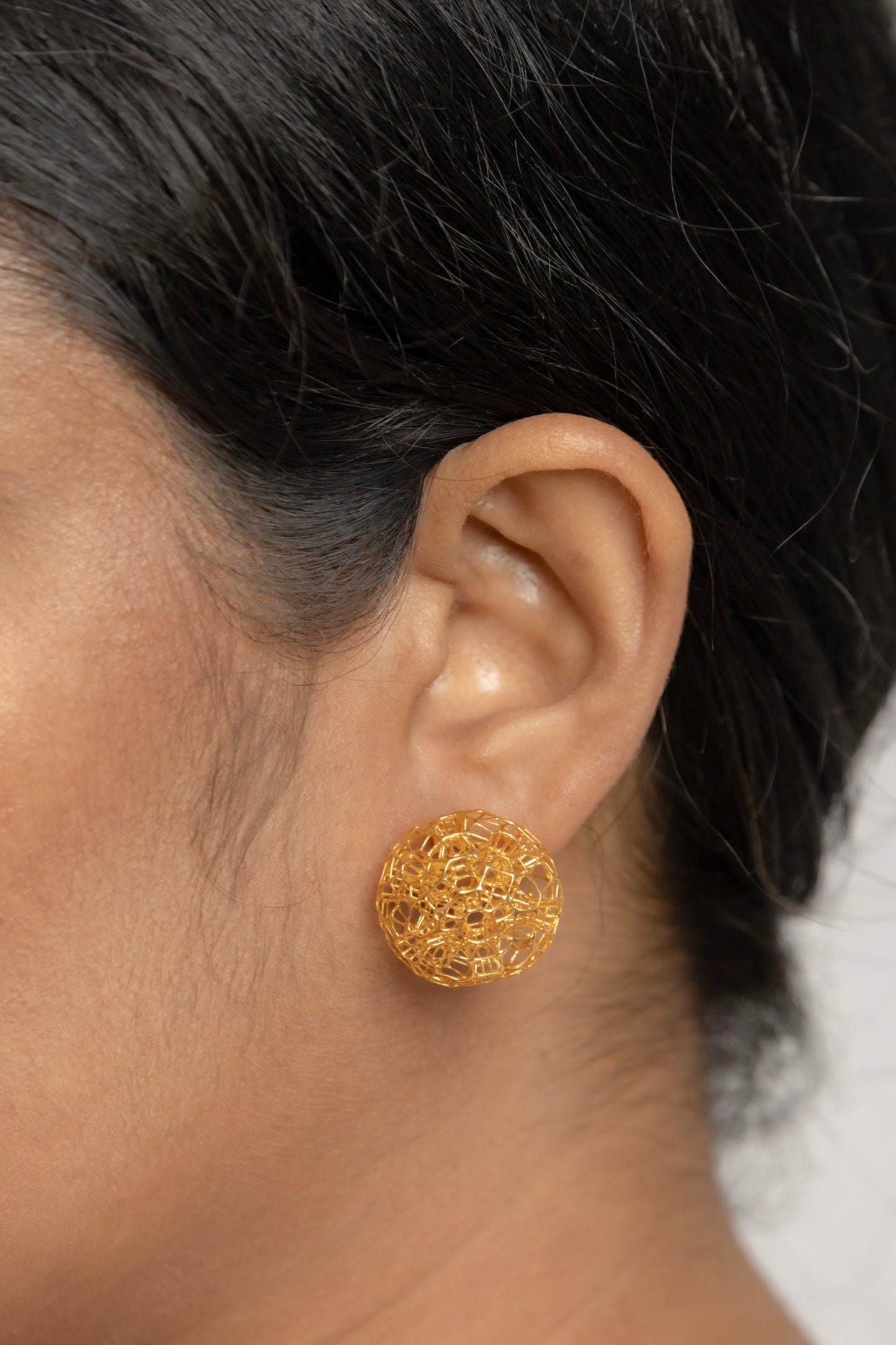 Model wearing Celestara Orbs 18K gold stud earrings showcasing their elegant everyday fit.