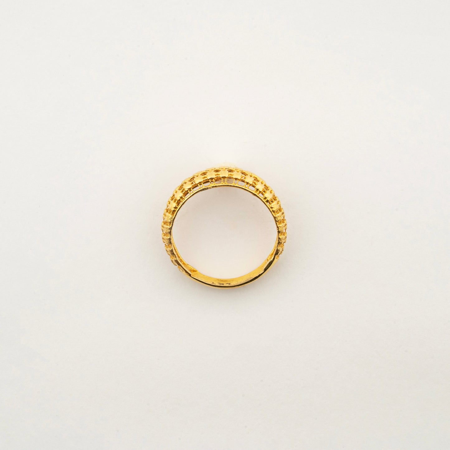 Top view of the Sculptyx Corda Flare 18K gold textured band ring.