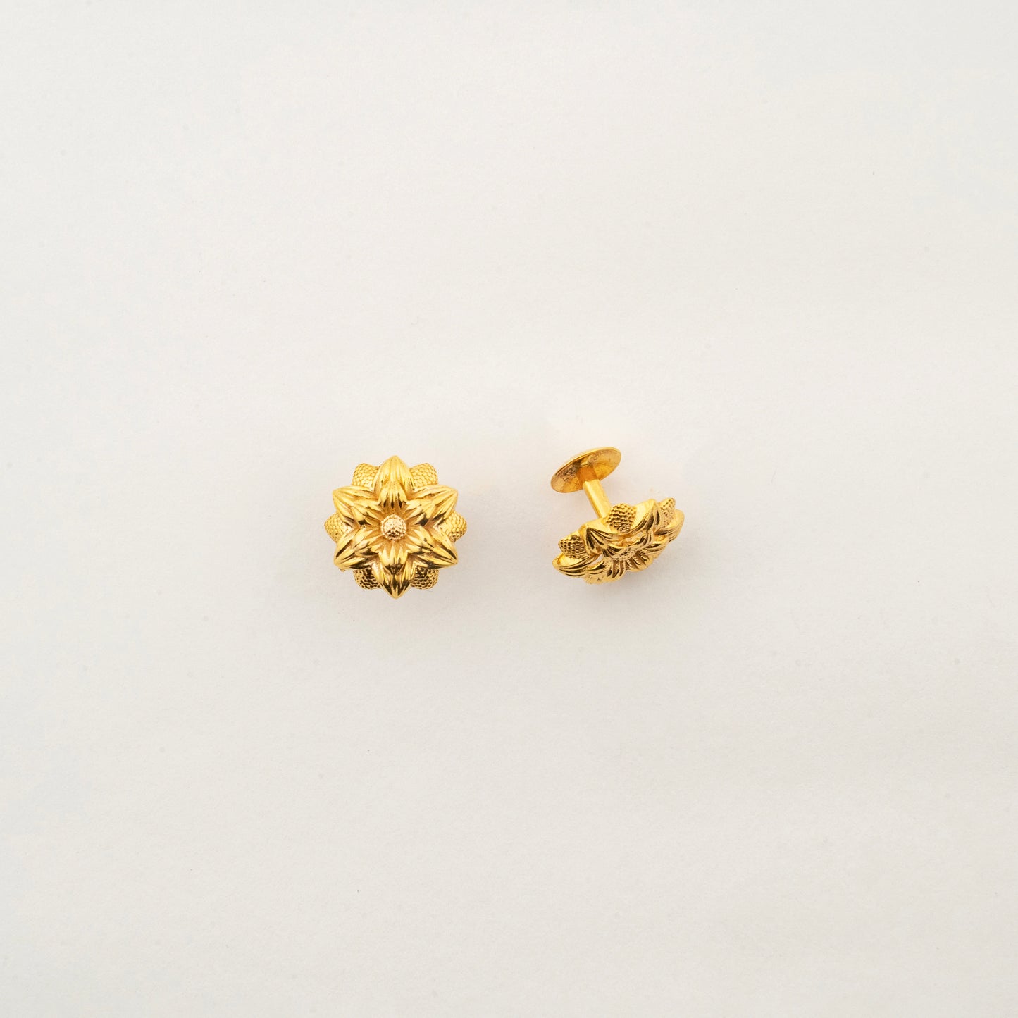 Close-up of Sculptyx Florent Hexa 18K gold stud earrings highlighting intricate floral craftsmanship.