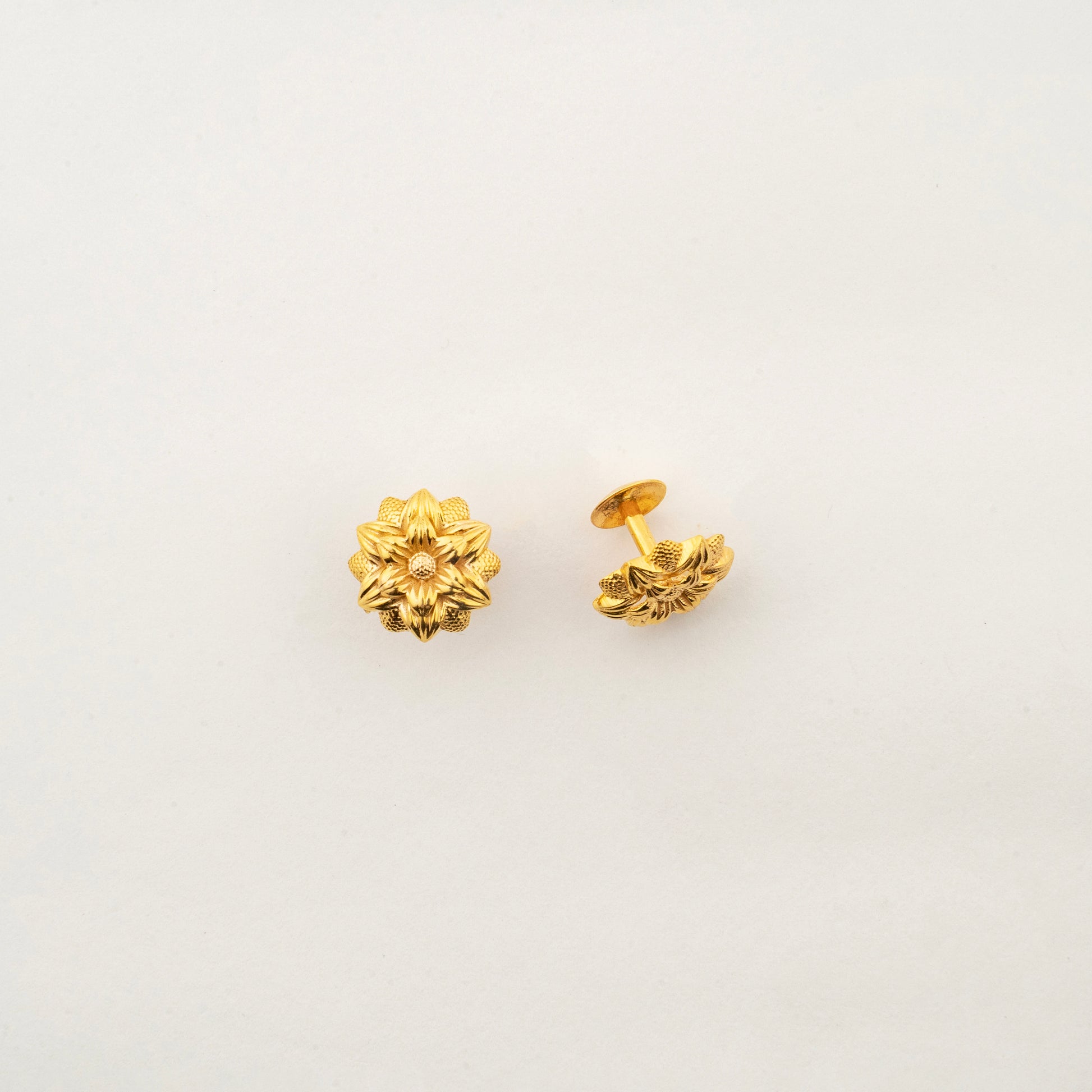 Close-up of Sculptyx Florent Hexa 18K gold stud earrings highlighting intricate floral craftsmanship.