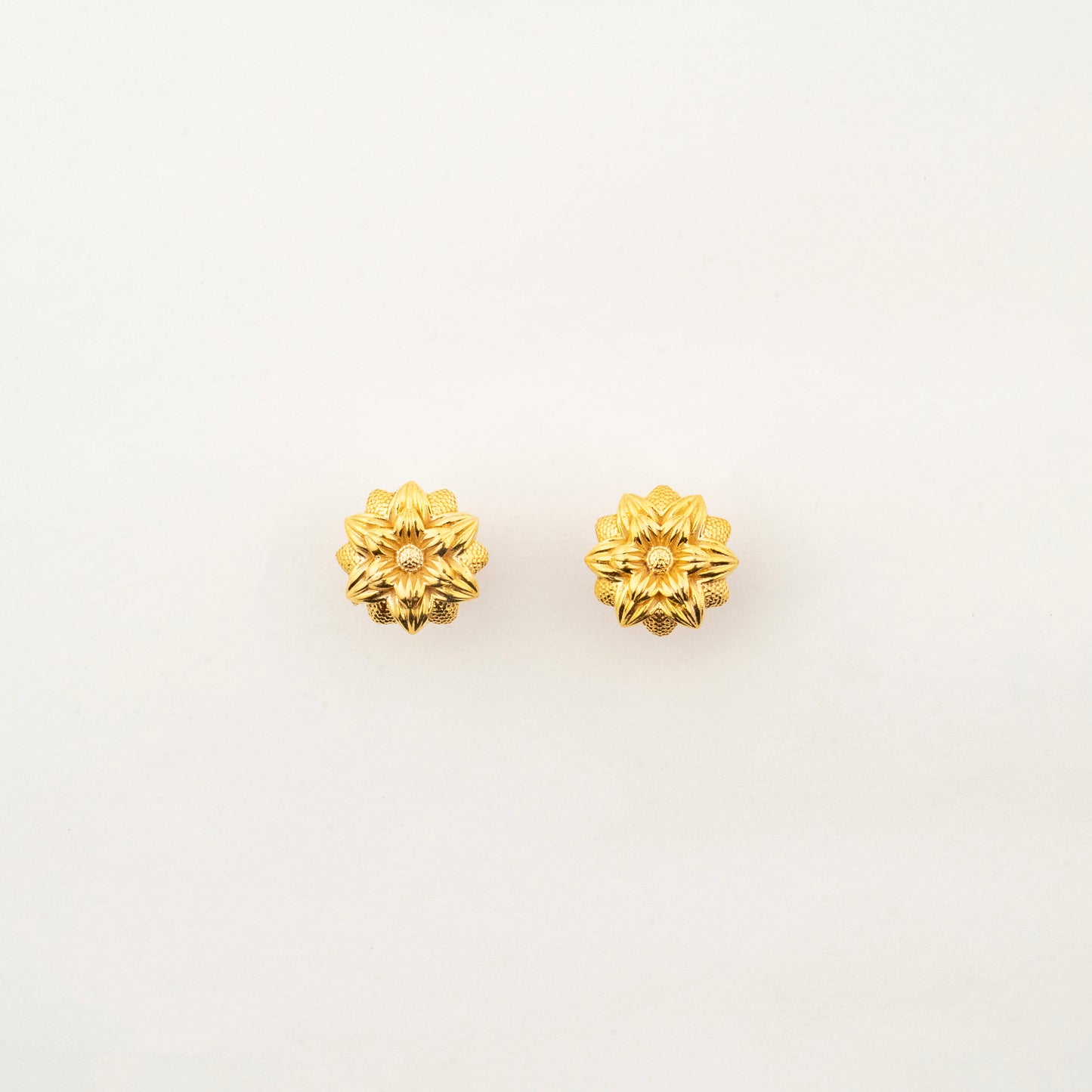 Sculptyx Florent Hexa handcrafted 18K gold floral stud earrings featuring a geometric six-petal botanical design.