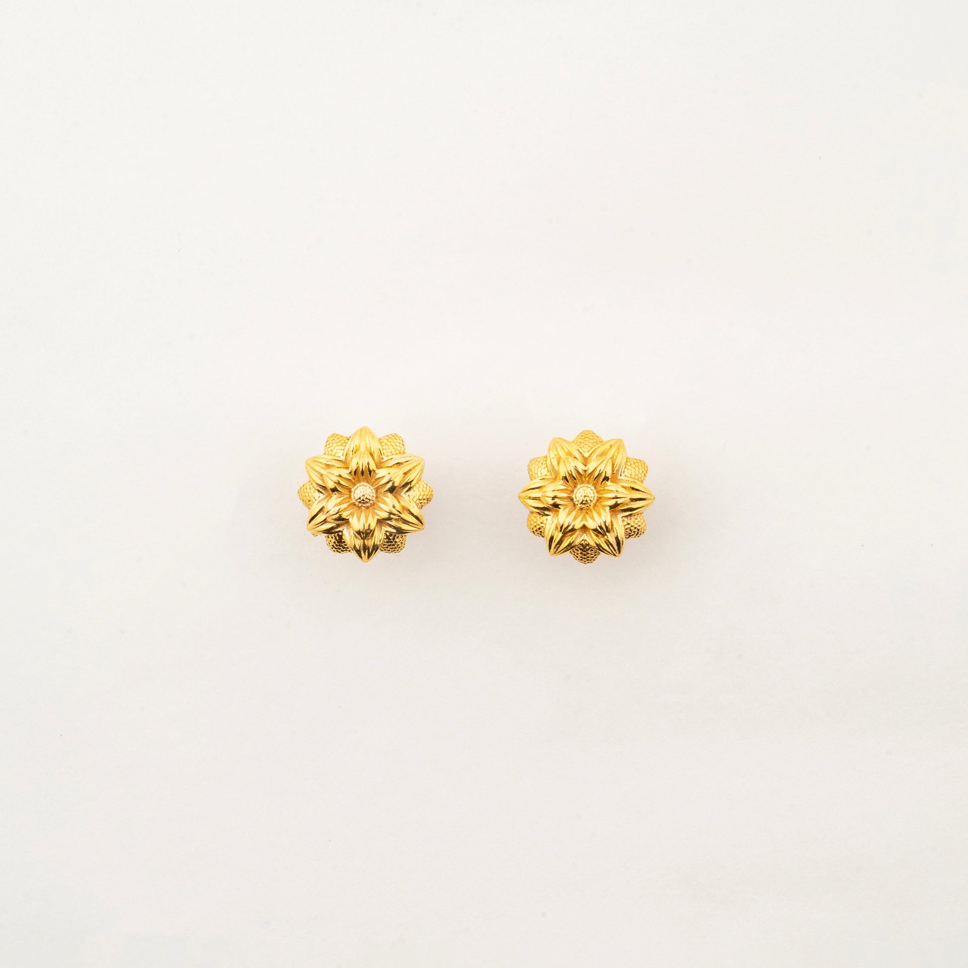 Sculptyx Florent Hexa handcrafted 18K gold floral stud earrings featuring a geometric six-petal botanical design.