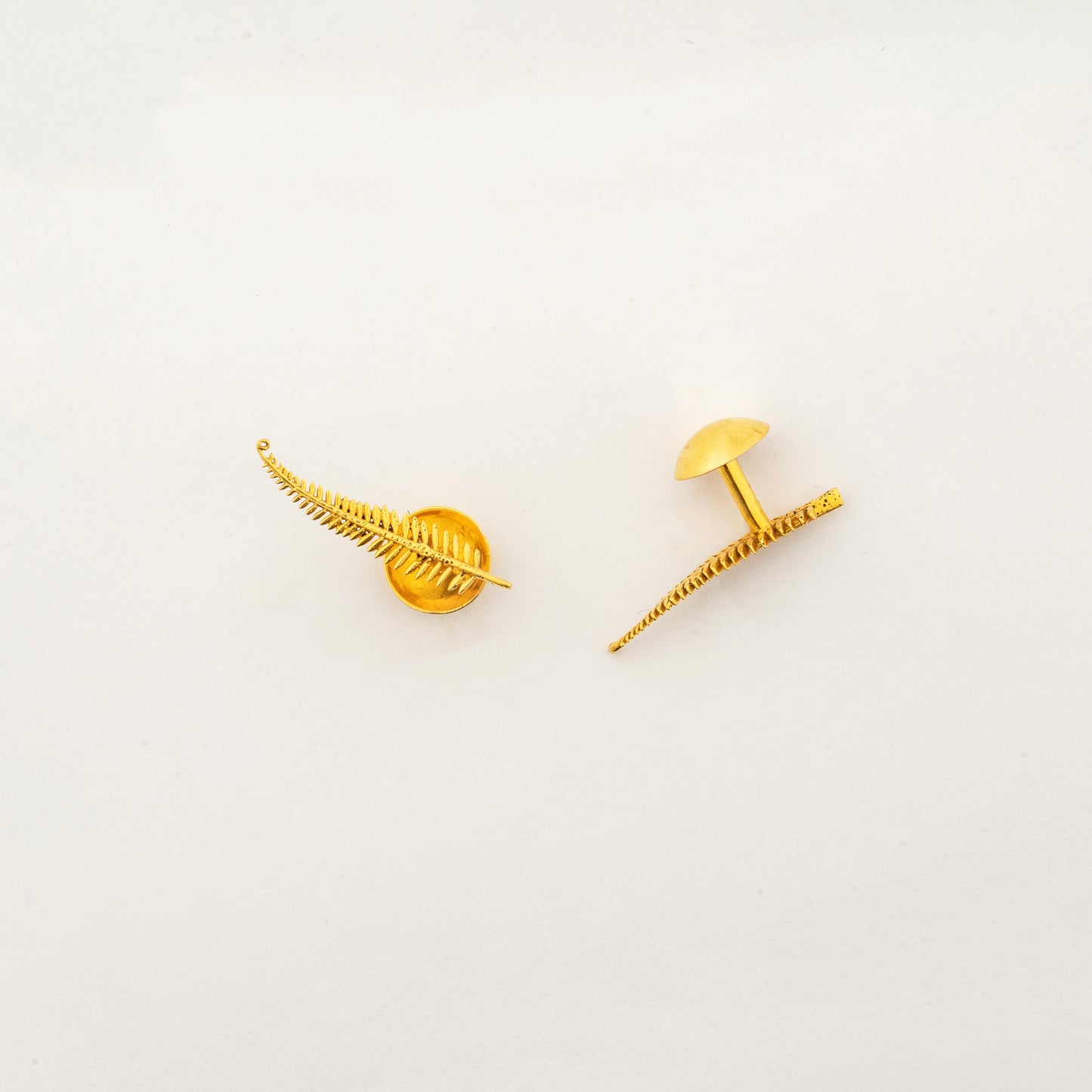 Close-up of Sculptyx Frondelle 18K gold botanical stud earrings showcasing intricate fern-inspired craftsmanship.