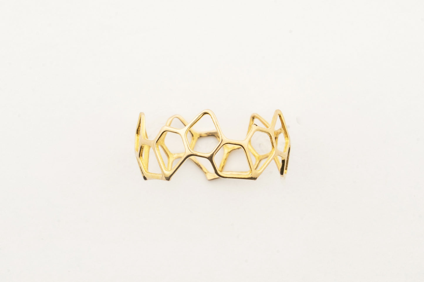 Sculptyx Hivemind handcrafted 18K gold geometric statement ring featuring an open honeycomb-inspired contemporary design.