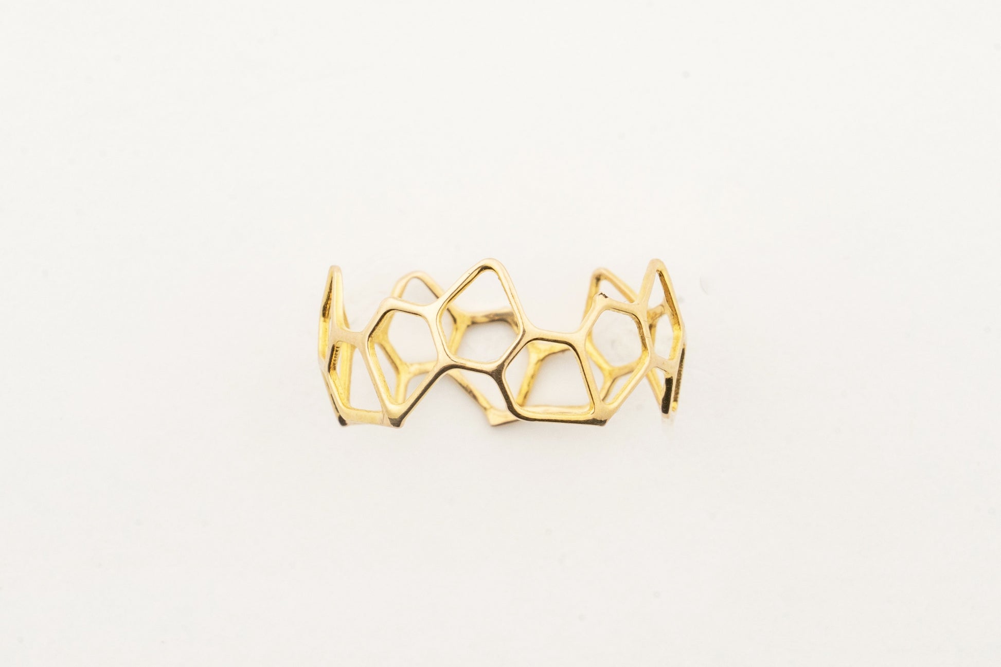Sculptyx Hivemind handcrafted 18K gold geometric statement ring featuring an open honeycomb-inspired contemporary design.