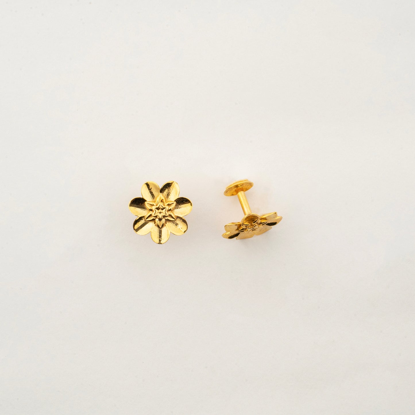 Close-up of Sculptyx Lunara Bloom 18K gold floral stud earrings highlighting intricate handcrafted details.