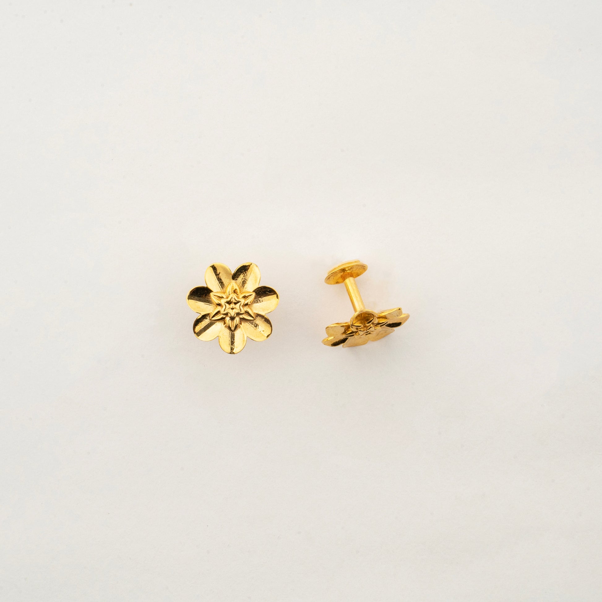 Close-up of Sculptyx Lunara Bloom 18K gold floral stud earrings highlighting intricate handcrafted details.