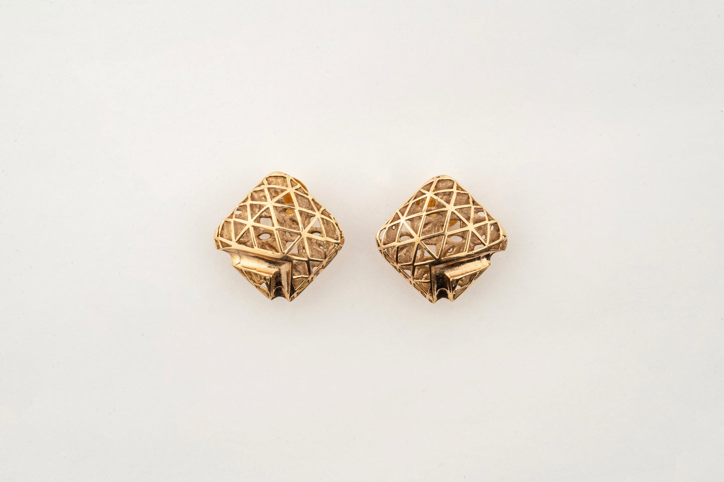 Close-up of Sculptyx Quadora Gridelle 18K gold geometric stud earrings showcasing precision handcrafted lattice detailing.