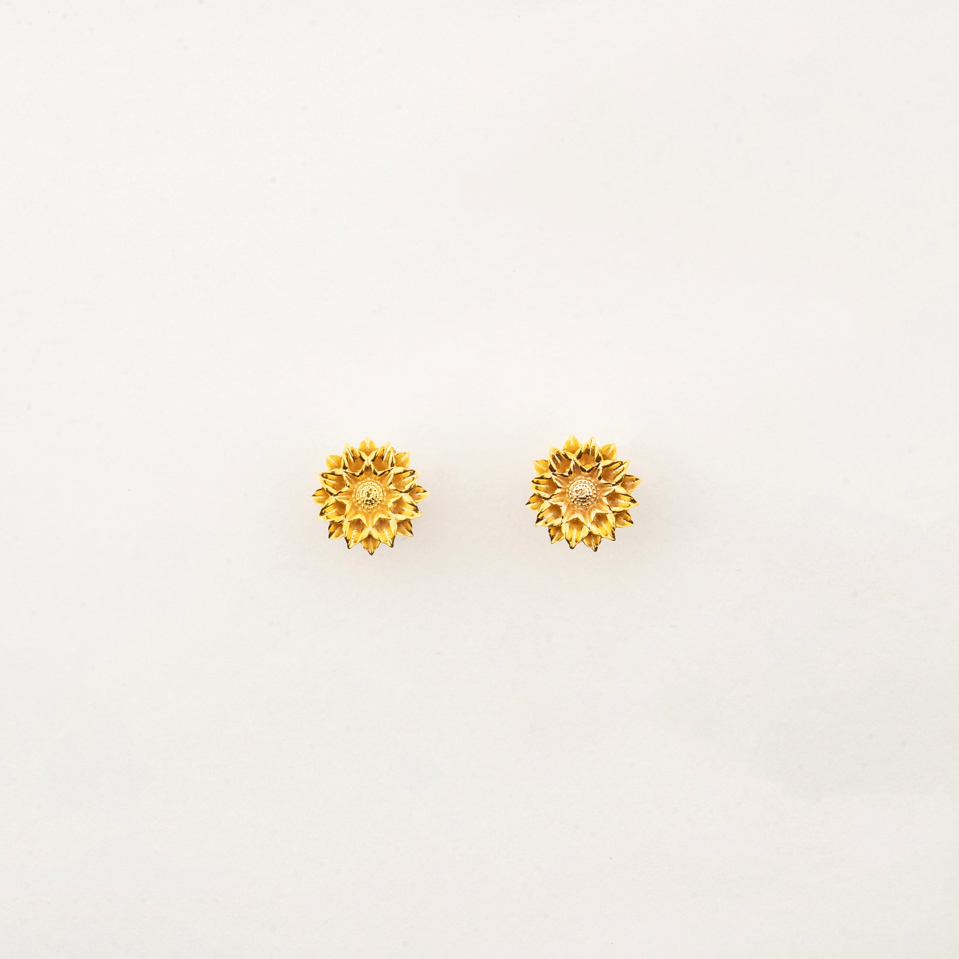 Sculptyx Solaris Crest handcrafted 18K gold stud earrings featuring a radiant sun-inspired floral design for everyday luxury.