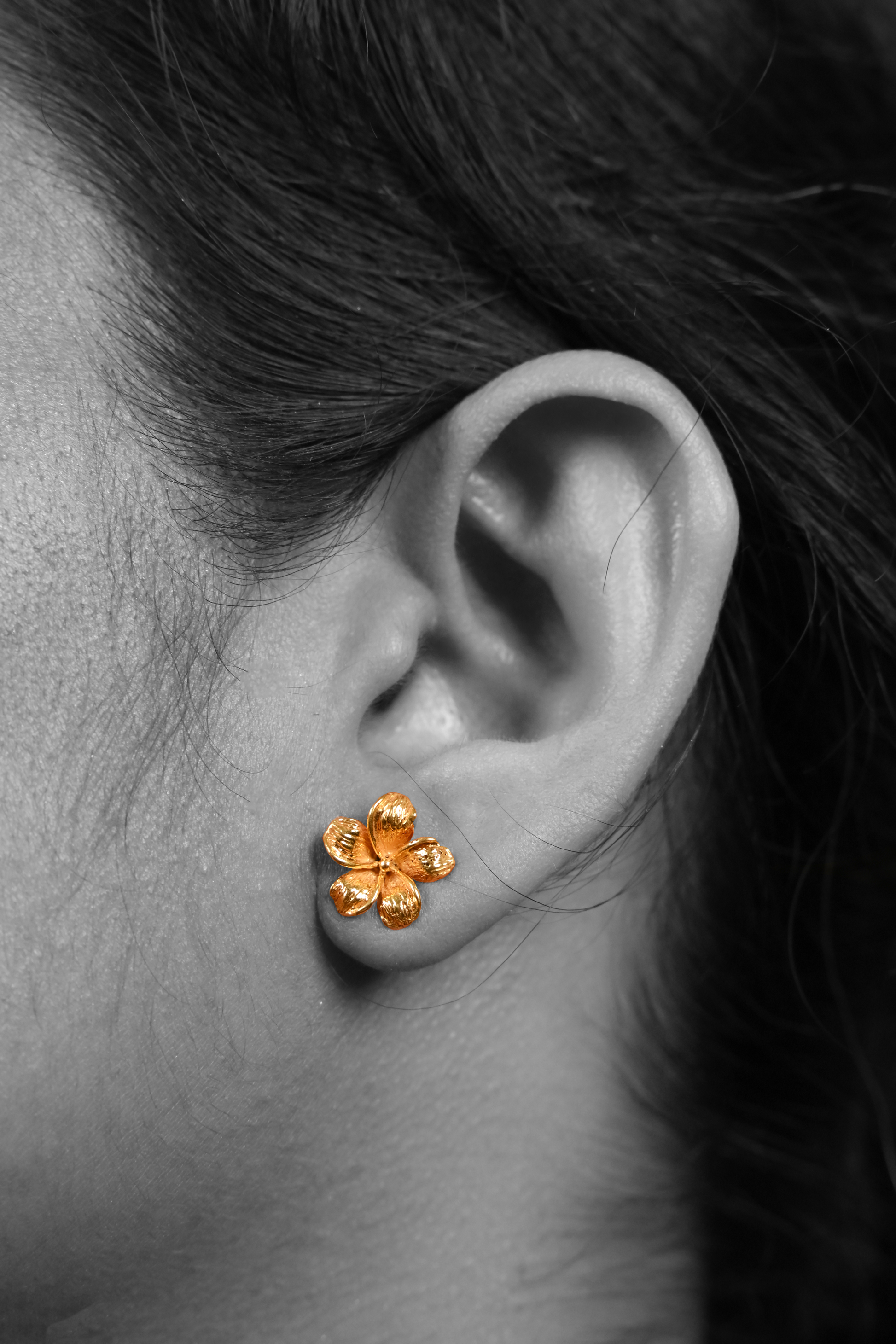 Model wearing Sculptyx The Blooming Hour handcrafted 18K gold floral stud earrings.