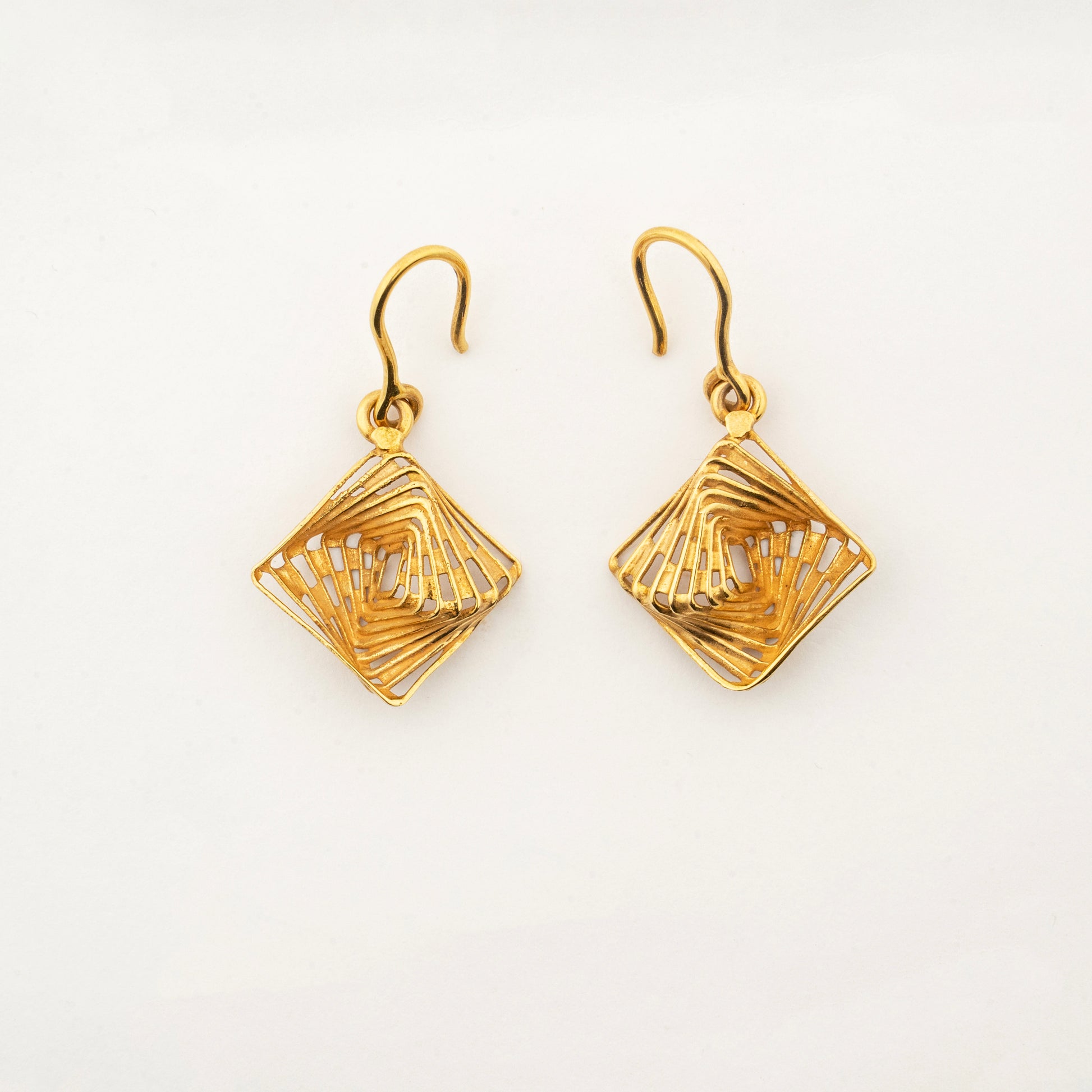 Sculptyx The Golden Parallax handcrafted 18K gold geometric drop earrings featuring an intricate openwork diamond design.