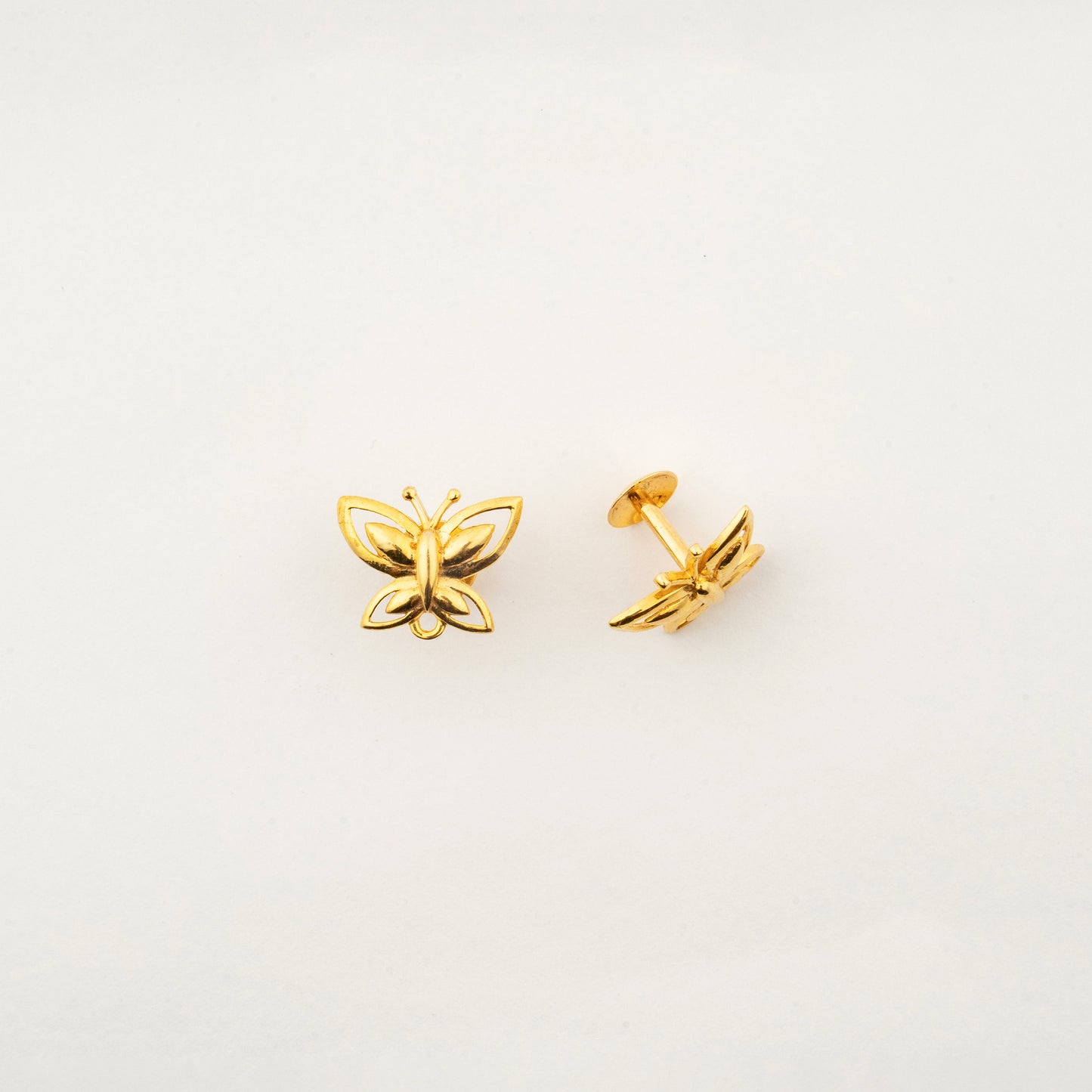 Close-up of handcrafted 18K gold butterfly stud earrings by Sculptyx showcasing refined butterfly wing detailing.