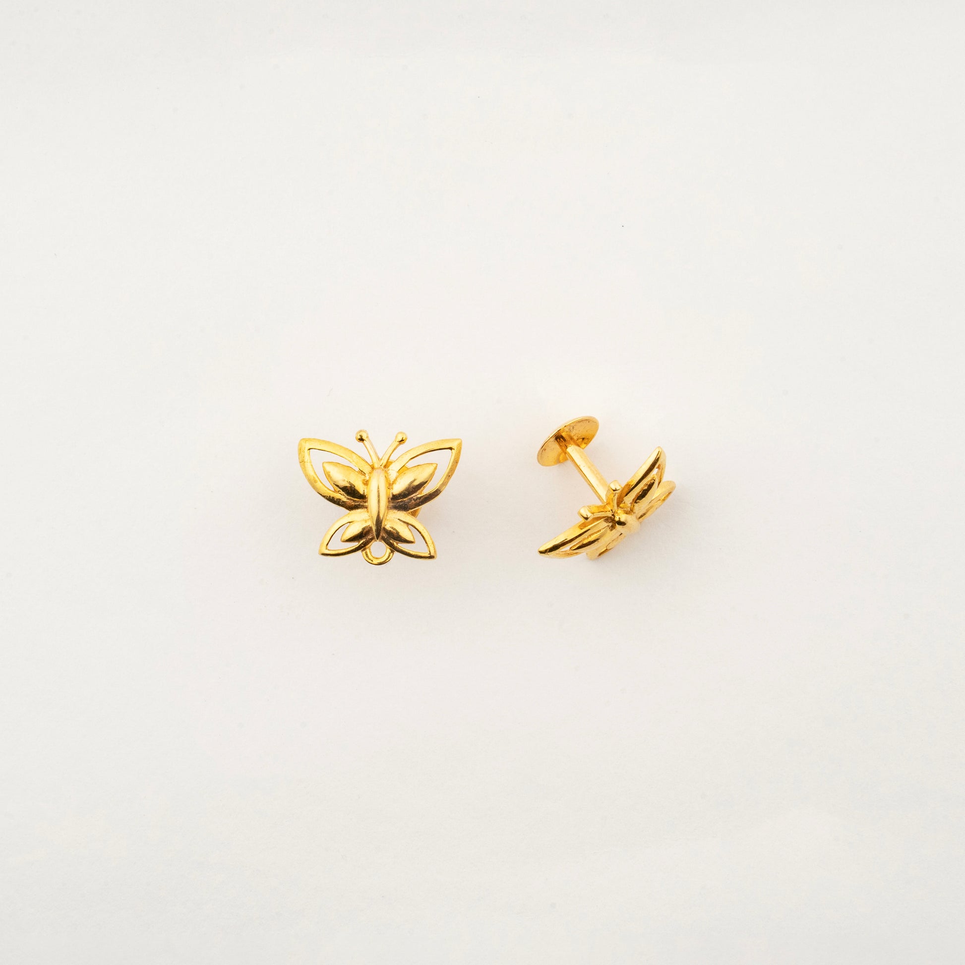 Close-up of handcrafted 18K gold butterfly stud earrings by Sculptyx showcasing refined butterfly wing detailing.