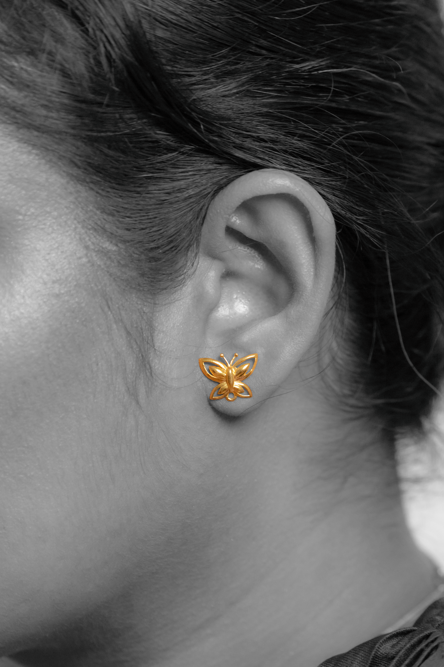 Model wearing Sculptyx The Lightning Stud handcrafted 18K gold butterfly stud earrings.