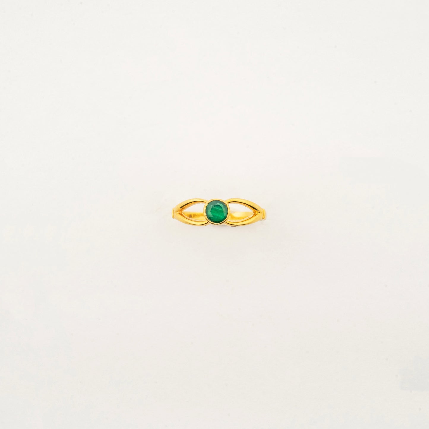 Sculptyx Verdant Axis handcrafted 22K gold emerald statement ring featuring a vibrant green gemstone in a modern minimalist setting.