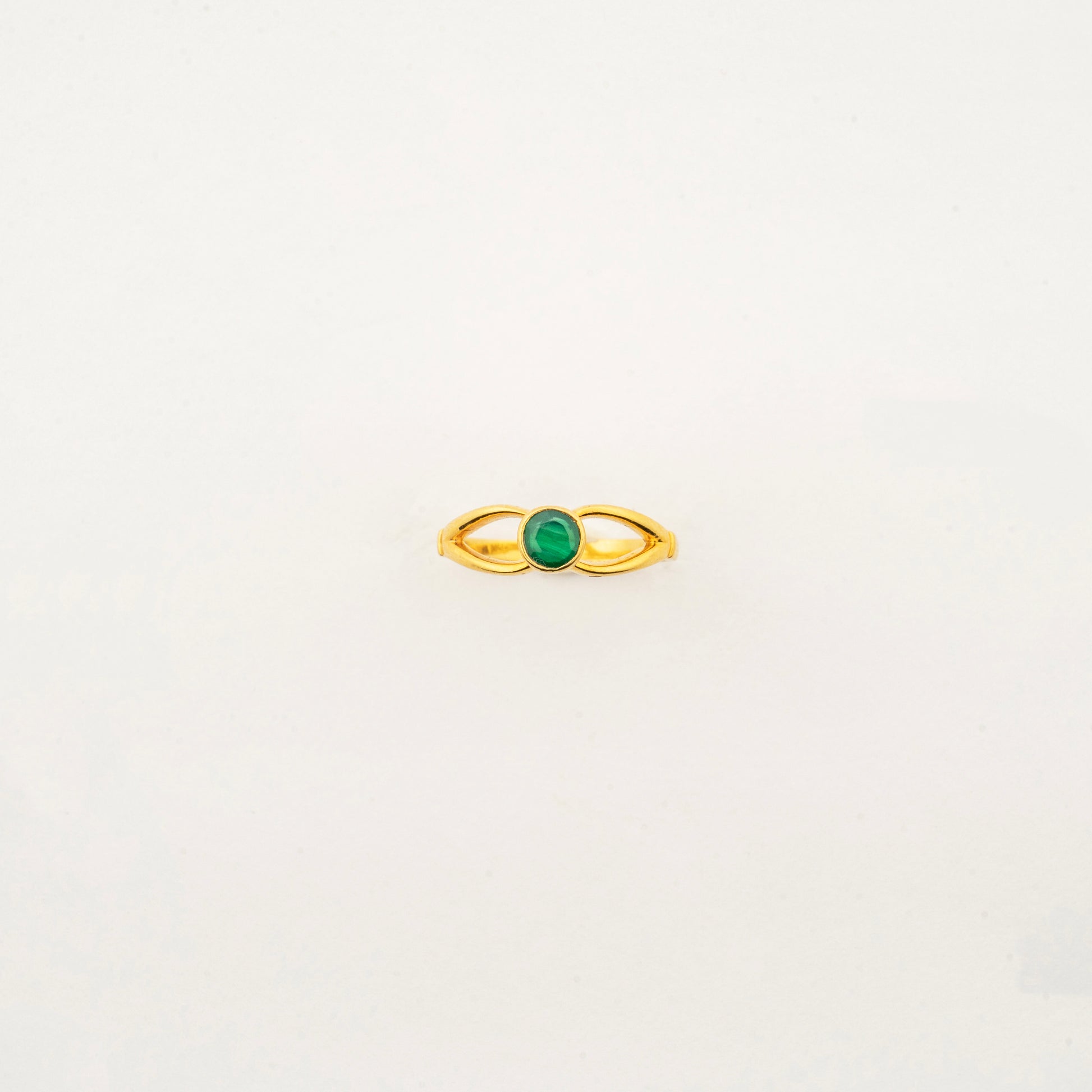 Sculptyx Verdant Axis handcrafted 22K gold emerald statement ring featuring a vibrant green gemstone in a modern minimalist setting.