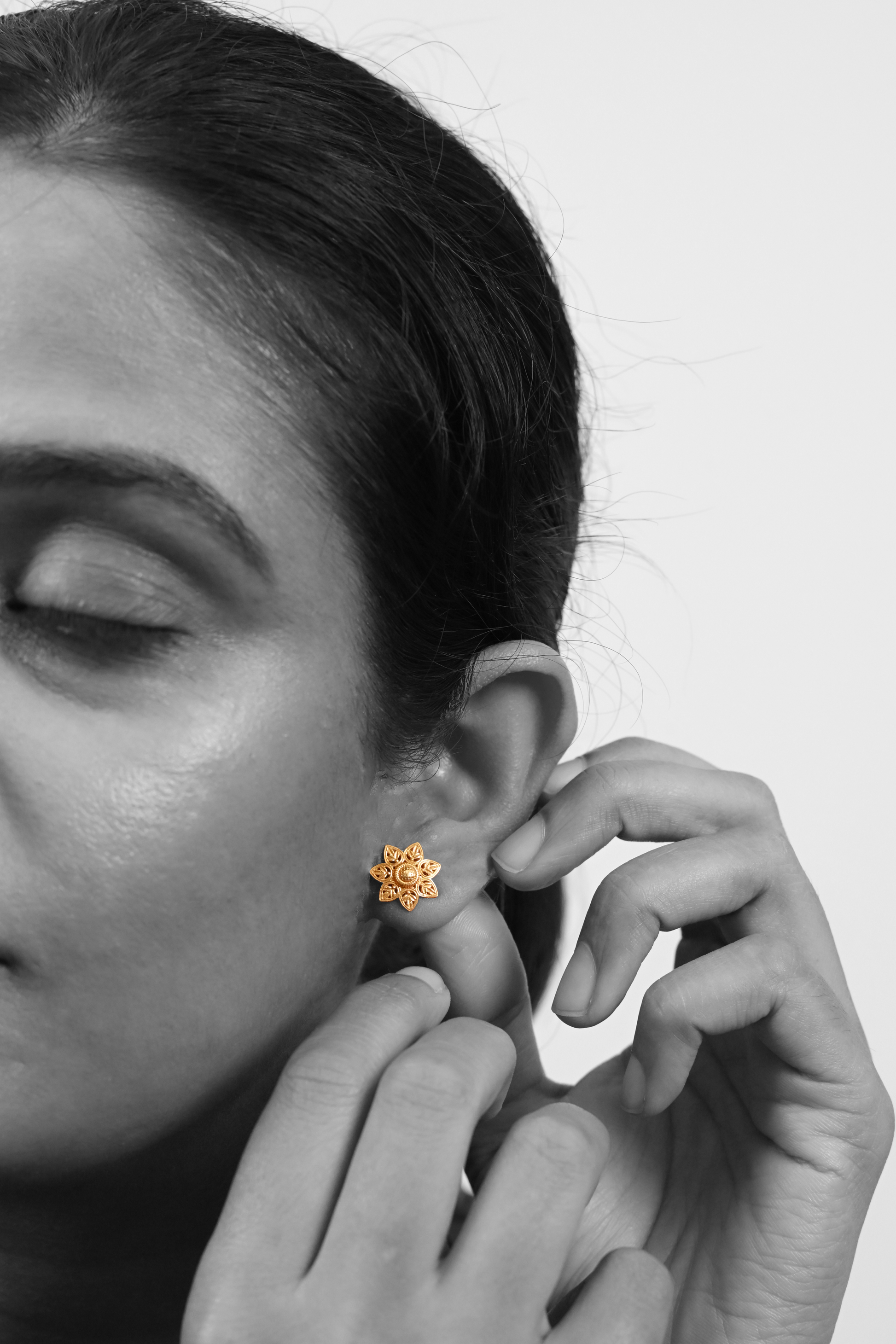 Model wearing Sculptyx Verdelis Six handcrafted 18K gold botanical leaf stud earrings.