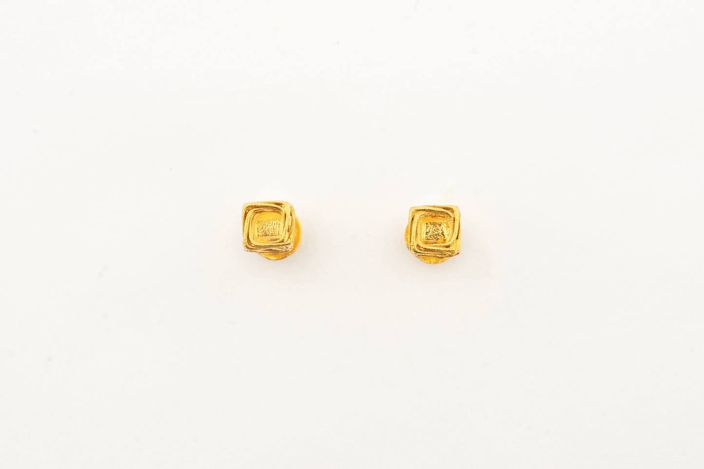Front view of the Sculptyx Vertex Vault 18K gold stud earrings showcasing their clean architectural cube design.