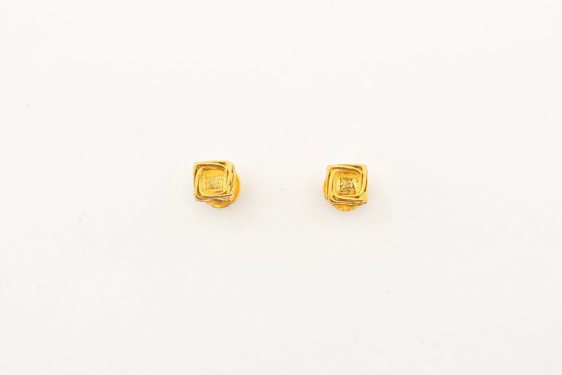 Front view of the Sculptyx Vertex Vault 18K gold stud earrings showcasing their clean architectural cube design.