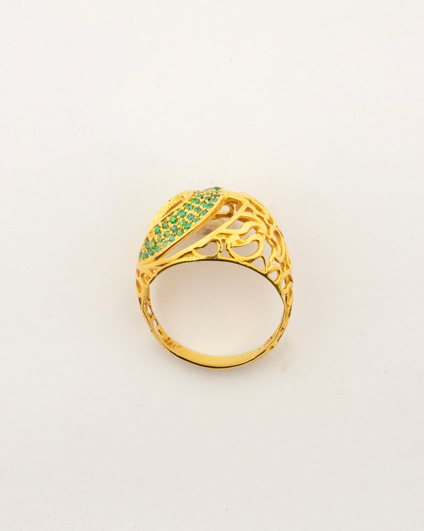 Top view of the Sculptyx Vrideluna 14K gold statement ring with shimmering green crystal accents.